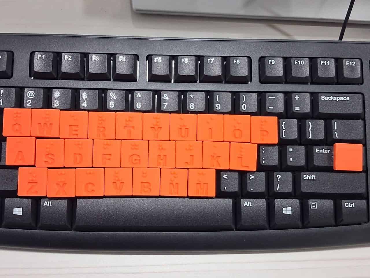 Close-up of orange keyboard overlays with raised Braille dots